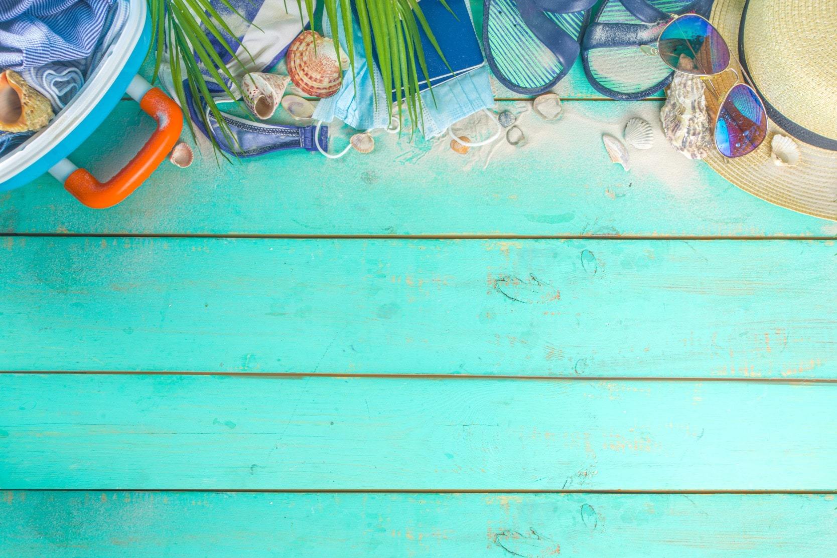 Summer holiday items against wooden boards painted teal